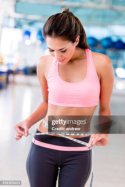 fit woman measuring her waist - smiling woman waist up stock pictures, royalty-free photos & images