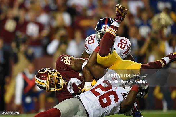 Tight end Niles Paul of the Washington Redskins is upended during their game against the New York Giants at FedExField on September 25, 2014 in...