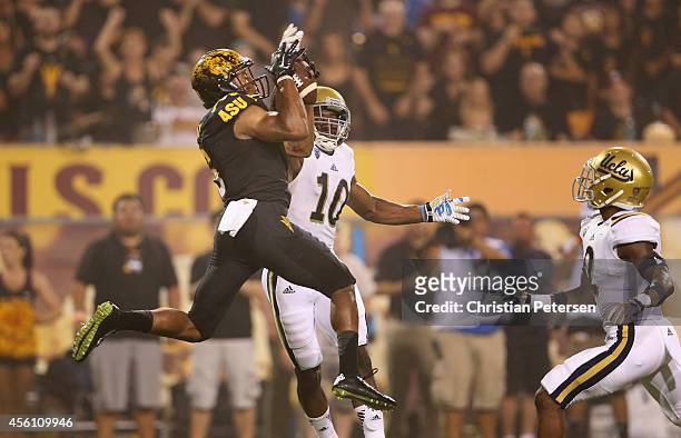 Wide receiver Cameron Smith of the Arizona State Sun Devils catches a 29 yard touchdown reception over defensive back Fabian Moreau of the UCLA...