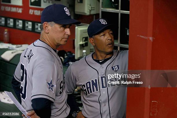 Manager Bud Black of the San Diego Padres and bench coach Dave Roberts of the Padres look over the roster during the seventh inning of a MLB game...
