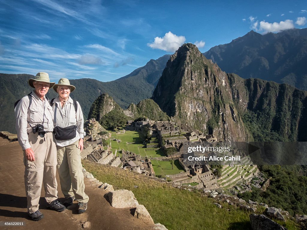 Senior tourist couple with view of Machu Picchu