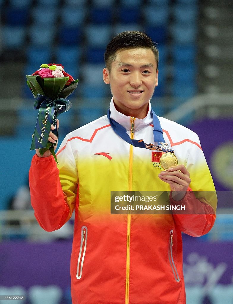 Gold medalist Dong Dong of China poses during the medal ceremony for