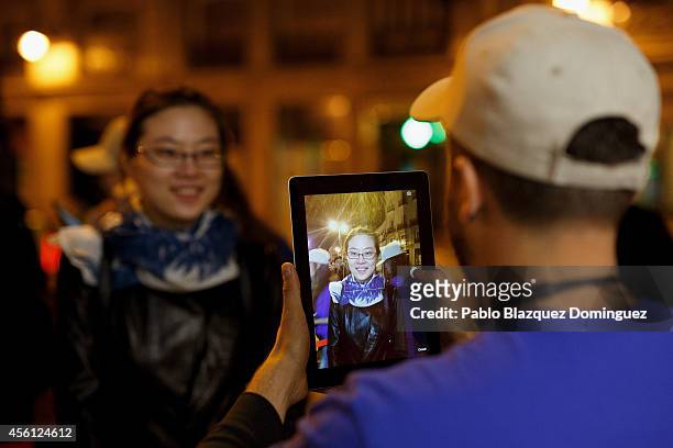An Apple's employee takes a picture of a customer queueing to reserve a model of iPhone for her in the early hours prior to the opening of Puerta del...