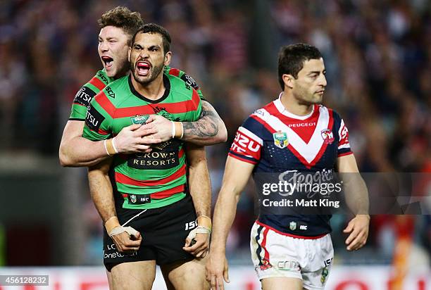 Greg Inglis of the Rabbitohs celebrates Chris McQueen after scoring his second try as Anthony Minichiello of the Roosters looks dejected during the...