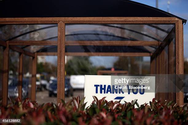 Thank You" sign sits on a shopping cart shelter outside a Tesco Extra supermarket store, operated by Tesco Plc, in the Surrey Quays district of...