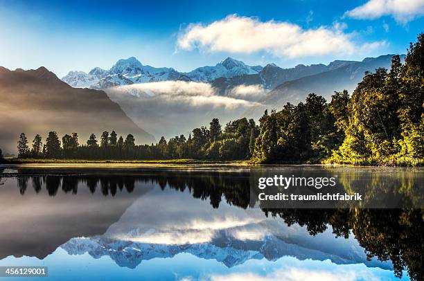 lake matheson at sunrise - lake matheson foto e immagini stock