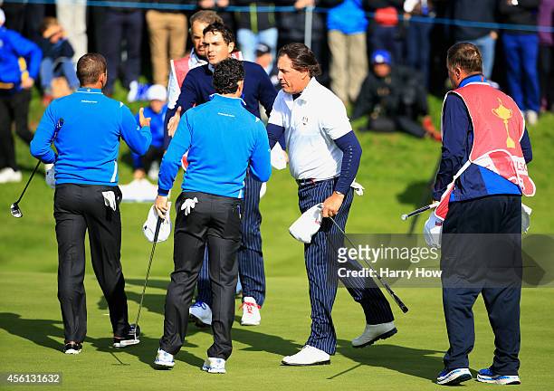 Phil Mickelson and Keegan Bradley of the United States shake hands with Rory McIlroy and Sergio Garcia of Europe on the 18th green after the Morning...