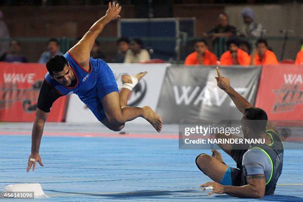 Royal Kings USA kabaddi player gestures as a United Singhs opponent reacts during a World Kabaddi League match in Amritsar on September 26, 2014....