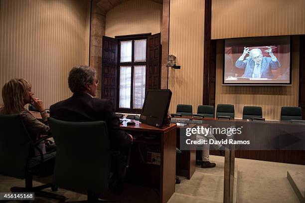 Jornalist watch to Former Catalan President Jordi Pujol on a screen as he speaks to the members of the parliament on September 26, 2014 in Barcelona,...