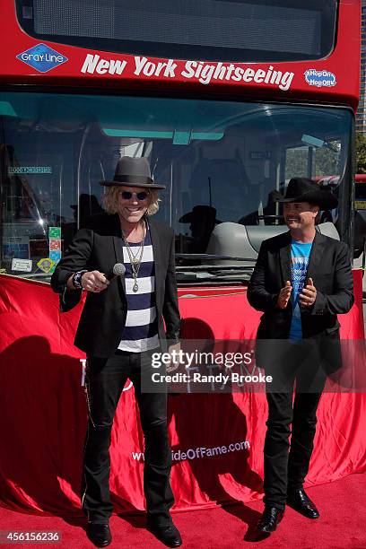 Big & Rich's Big Kenny and John Rich pose in fron of their Greyline "Ride of Fame" tour bus at Pier 78 on September 26, 2014 in New York City.