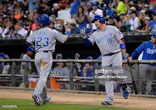 Billy Butler of the Kansas City Royals fist bumps teammate Norichika Aoki after Aoki scored on an RBI single hit by Lorenzo Cain during the first...