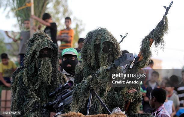 Izz ad-Din al-Qassam Brigades attend the ceremony held for the Palestinian martyrs who lost their lives during Israeli shelling on Gaza Strip on...
