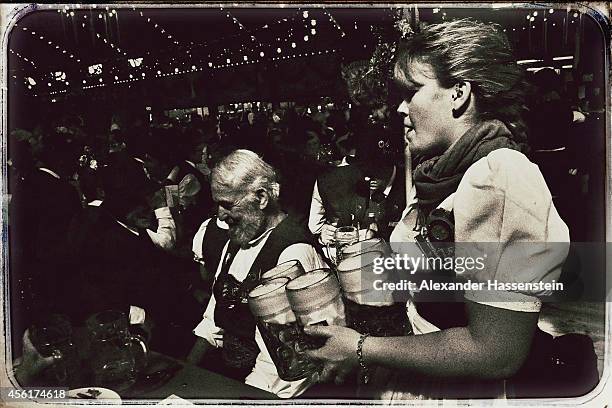 Waitress serves beer at Augustiner Beer tent after the Parade of Costumes and Riflemen on the second day of the 2014 Oktoberfest at Theresienhoehe on...