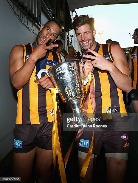 Josh Gibson and Ben Stratton of the Hawks walk off the field with the Premeirship Cup during the 2014 AFL Grand Final match between the Sydney Swans...