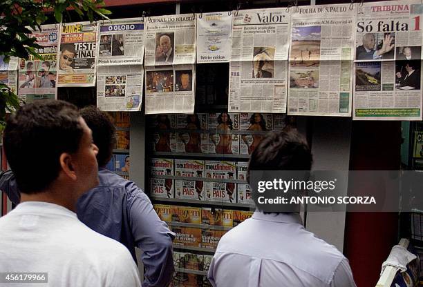 Passers-by read newspaper headlines announcing the resignation of two Brazilian senators, 25 May 2001, in a kiosk, Rio de Janeiro, Brazil....