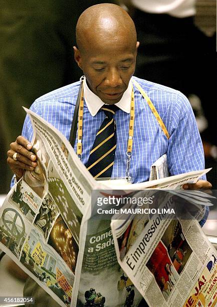 Trader on the stock exchange in Sao Paulo reads news of the war in Iraq in a newspaper 20 March 2003. AFP PHOTO/Mauricio LIMA Un operador de la Bolsa...