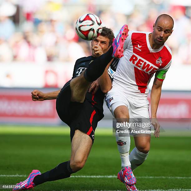 Thomas Mueller of Muenchen is challenged by Miso Brecko of Koeln during the Bundesliga match between 1. FC Koeln and FC Bayern Muenchen at...