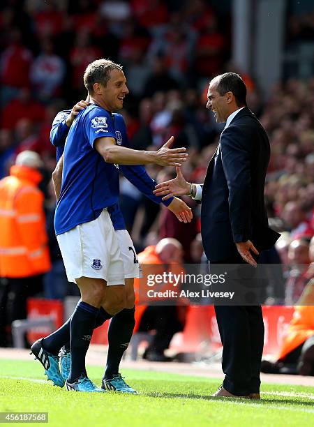 Phil Jagielka of Everton celebrates with Roberto Martinez the manager of Everton after scoring a late goal to level the scores at 1-1 during the...
