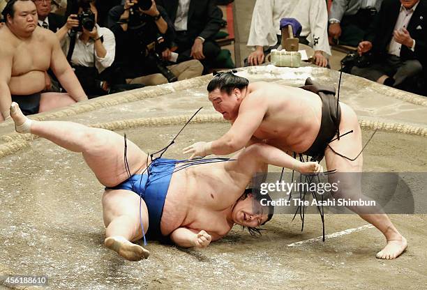 Hakuho throws Ichinojo to win on the day fourteen of Grand Sumo Autumn Tournament at Ryogoku Kokugikan on September 27, 2014 in Tokyo, Japan.