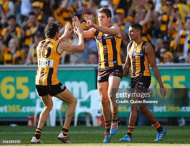 Luke Breust of the Hawks is congratulated by Isaac Smith after kicking a goal during the 2014 AFL Grand Final match between the Sydney Swans and the...