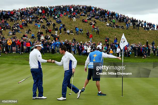 Victor Dubuisson and Graeme McDowell of Europe celebrate on the 3rd green during the Afternoon Foursomes of the 2014 Ryder Cup on the PGA Centenary...