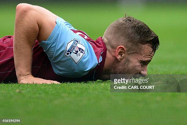 Aston Villa's English midfielder Tom Cleverley lies on the ground after being tackled during the English Premier League football match between...