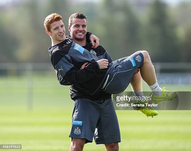 Steven Taylor smiles whilst holding Jack Colback during a training session at The Newcastle United Training Centre on September 27 in Newcastle upon...