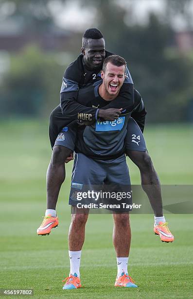Steven Taylor laughs as Cheick Tiote jumps on his back during a training session at The Newcastle United Training Centre on September 27 in Newcastle...