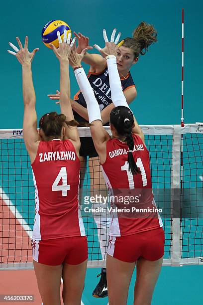 Anna Buijs of Netherlands spikes as Ekaterina Gamova and Irina Zaryazhko of Russia block during the FIVB Women's World Championship pool C match...