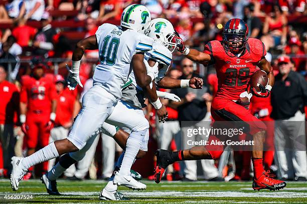 Justin Goodwin of the Rutgers Scarlet Knights runs past Leonard Davis and Rae Juan Marbley of the Tulane Green Wave in the fourth quarter at High...
