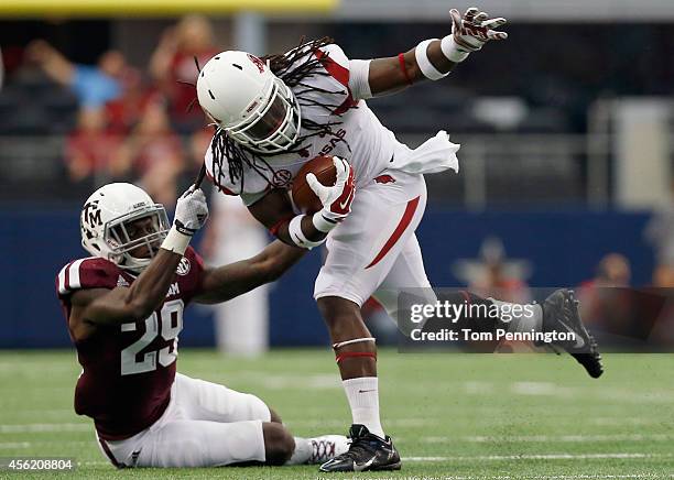 Alex Collins of the Arkansas Razorbacks carries the ball against Deshazor Everett of the Texas A&M Aggies in the firs half of the Southwest Classic...