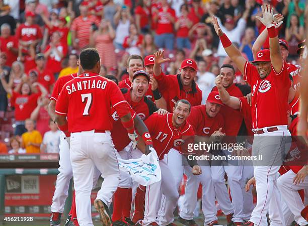 Ramon Santiago of the Cincinnati Reds celebrates his walk off grand slam home run with teammates in the 10th inning of play against the Pittsburgh...