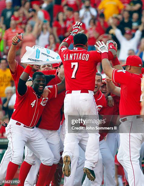 Ramon Santiago of the Cincinnati Reds celebrates his walk off grand slam home run with teammates in the 10th inning of play against the Pittsburgh...