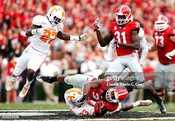 LaDarrell McNeil of the Tennessee Volunteers tackles Todd Gurley of the Georgia Bulldogs at Sanford Stadium on September 27, 2014 in Athens, Georgia.