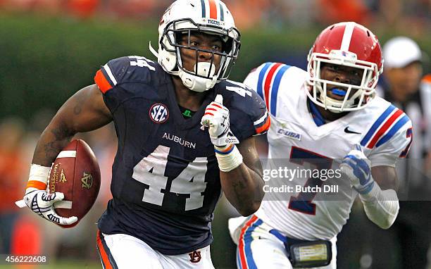 Running back Cameron Artis-Payne of the Auburn Tigers gets past defensive back Xavier Woods of the Louisiana Tech Bulldogs as he runs for a first...