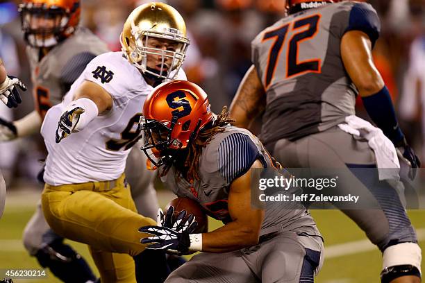 Running back Prince-Tyson Gulley of the Syracuse Orange runs in front of defensive lineman Grant Blankenship of the Notre Dame Fighting Irish during...