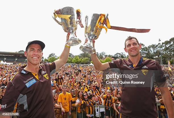 Alastair Clarkson the coach and Luke Hodge the captain of the Hawks hold up the 2013 and 2014 Premeirship Cups at the Hawthorn Hawks AFL team...