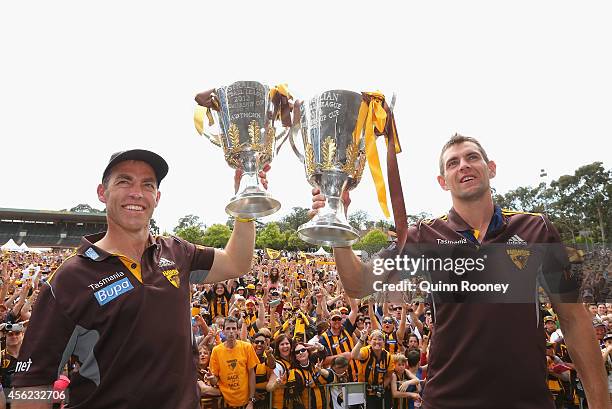 Alastair Clarkson the coach and Luke Hodge the captain of the Hawks hold up the 2013 and 2014 Premeirship Cups at the Hawthorn Hawks AFL team...