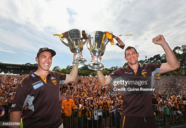 Alastair Clarkson the coach and Luke Hodge the captain of the Hawks hold up the 2013 and 2014 Premeirship Cups at the Hawthorn Hawks AFL team...