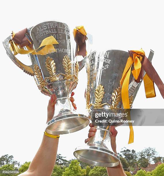 Alastair Clarkson the coach and Luke Hodge the captain of the Hawks hold up the 2013 and 2014 Premeirship Cups at the Hawthorn Hawks AFL team...