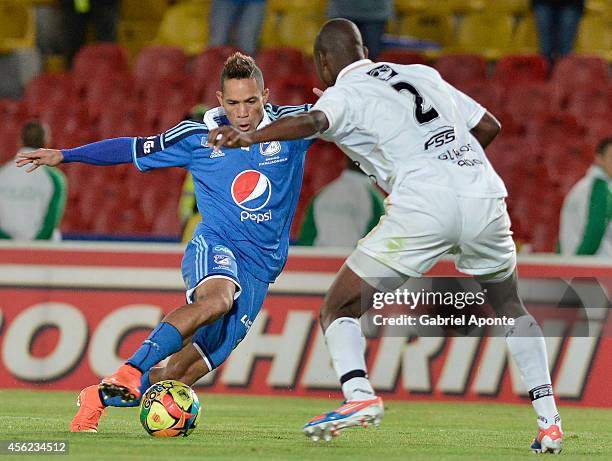 Andy Polo of Millonarios struggles for the ball with Yamith Cuesta of Fortaleza during a match between Millonarios and Fortaleza as part of Liga...