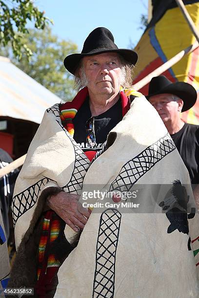 Neil Young is honored during a ceremony where he and Willie Nelson were presented with decorated buffalo hides before the Harvest The Hope Concert in...