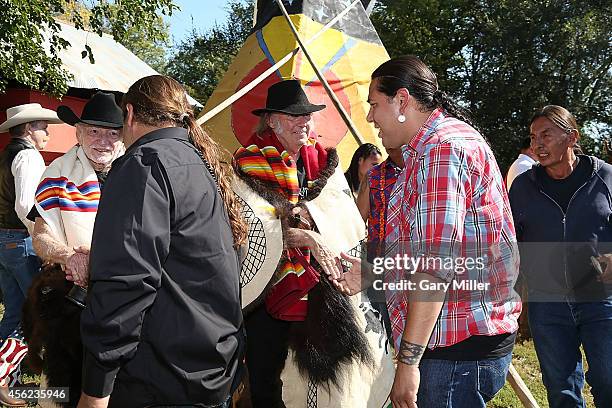 Willie Nelson and Neil Young greet Native Americans including Dallas Goldtooth during a ceremony where they were presented with decorated buffalo...