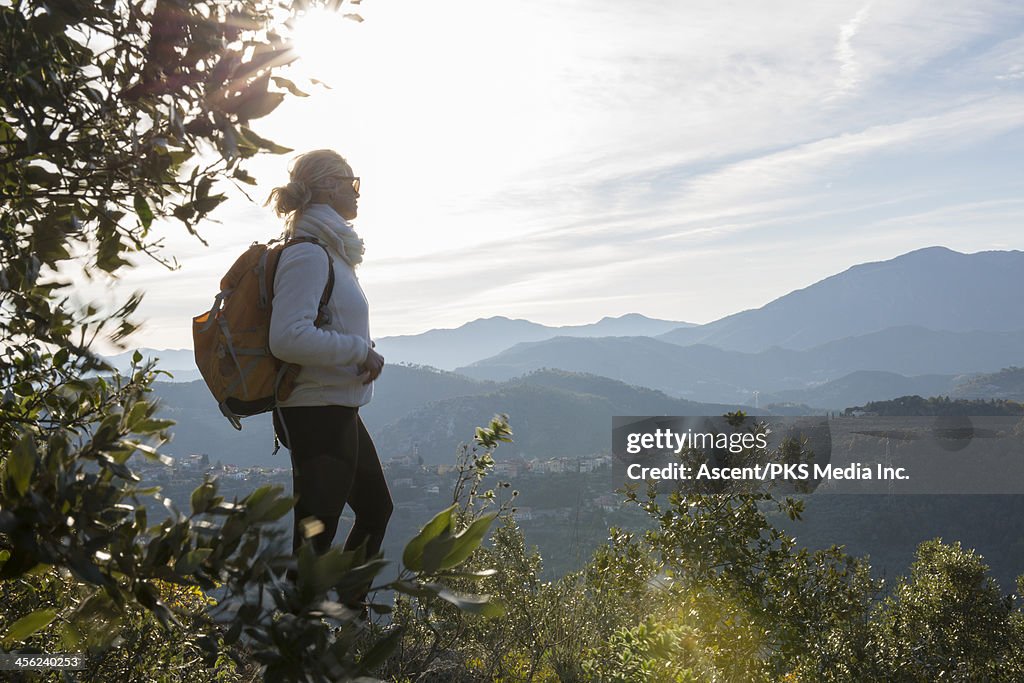 Hiker pauses to gaze over hills, forest view