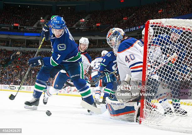 Devan Dubnyk of the Edmonton Oilers makes a save on David Booth of the Vancouver Canucks during their NHL game at Rogers Arena December 13, 2013 in...