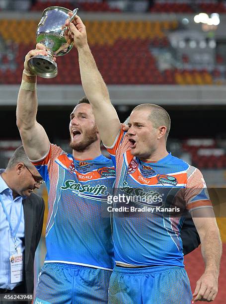 Brett Anderson and Jason Roos hold up the winners trophy after the Intrust Super Cup Grand Final match between Northern Pride and Easts Tigers at...