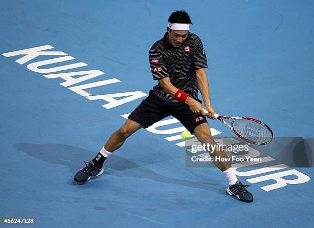 Kei Nishikori of Japan returns a shot to Julien Benneteau of France in the mens single finals during the Malaysian Open at Putra Stadium on September...