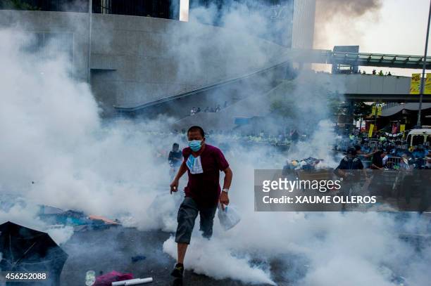 Pro-democracy demonstrator runs as police fired tear gas towards protesters near the Hong Kong government headquarters on September 28, 2014. Police...
