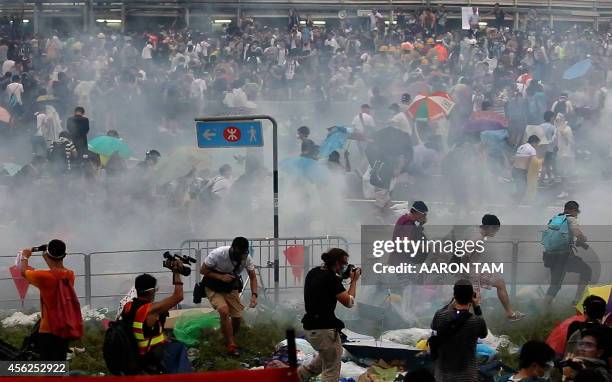 People disperse after police fired tear gas upon pro-democracy demonstrators near the Hong Kong government headquarters on September 28, 2014. Police...