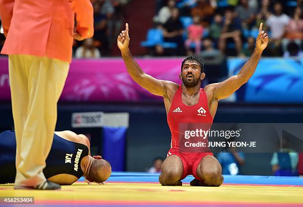 India's Yogeshwar Dutt reacts after winning the match against Tajikistan's Zalimkhan Yusupov in the men's freestyle 65 kg wrestling event for the...